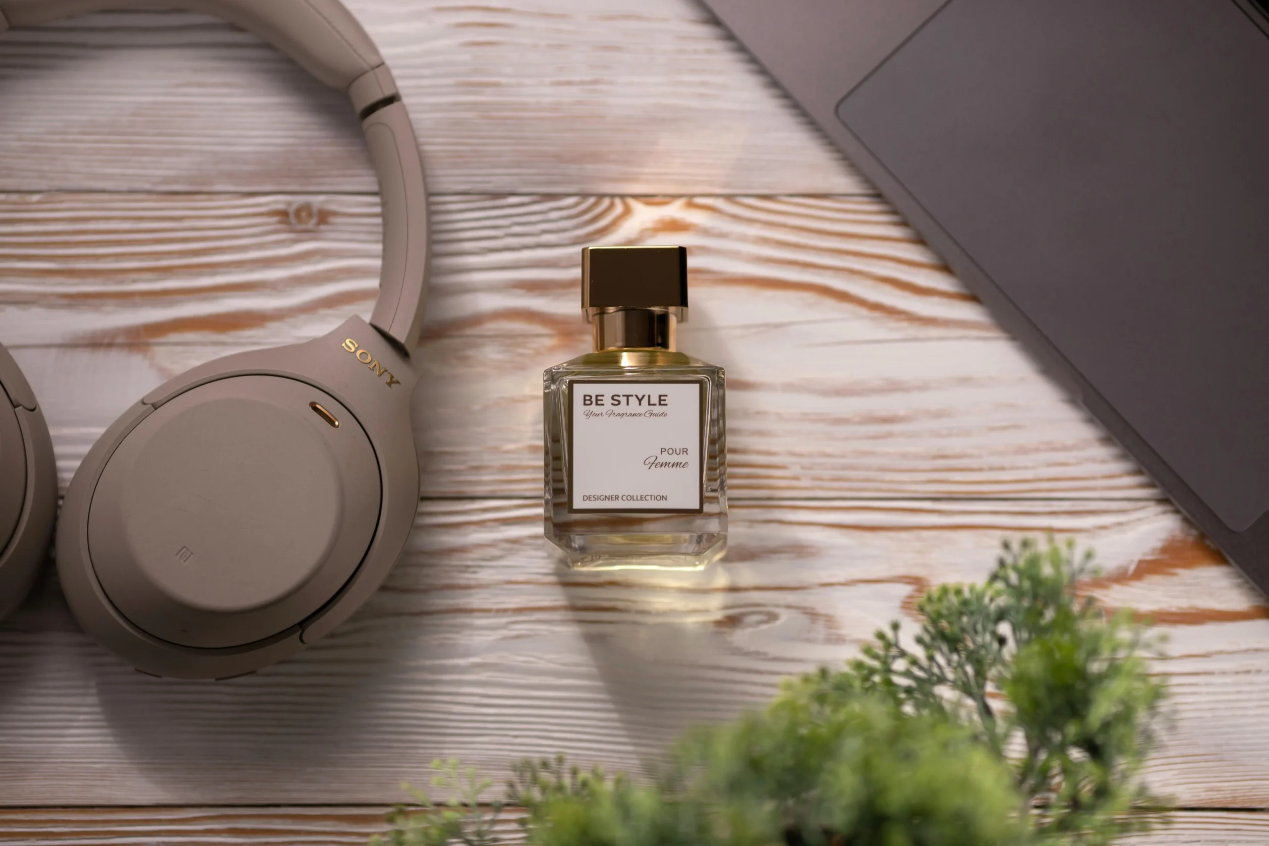 Product photography setup with headphones and perfume bottle on wooden background.Kochi-based photography service for events and products.